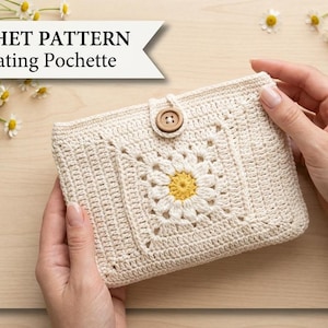 May include: A cream-colored crochet pochette featuring a central daisy motif with white petals and a yellow center, secured by a single brown wooden button. The image includes the text: PDF CROCHET PATTERN — Coordinating Pochette.