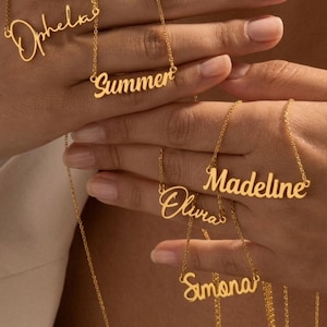 Op de afbeelding: Vijf goudkleurige metalen kettingen met aangepaste naamhangers in cursief schrift. De weergegeven namen zijn Ophelia, Summer, Madeline, Olivia en Simona. Elke ketting bestaat uit een fijne ketting bevestigd aan het naamplaatje. Een klein rond logo met de tekst Velunis is zichtbaar in de rechterbenedenhoek.