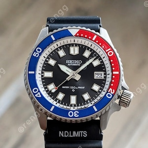 May include: A Seiko automatic wristwatch with a black dial, a date window, and luminous hands. The bezel is blue and red, with a stainless steel case and a black rubber strap. The watch is water-resistant to 150m.
