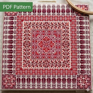May include: A square cross-stitch embroidery piece featuring a symmetrical geometric pattern in shades of red and dark burgundy on a cream-colored fabric. The design includes nested borders, floral motifs, and a central star-like element. PDF Pattern.