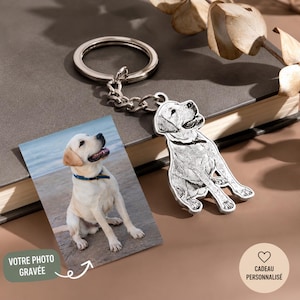 Peut inclure: Un porte-clés argenté en forme de chien, avec une chaîne et un anneau, à côté d'une photo d'un Labrador Retriever jaune. La photo porte le texte "VOTRE PHOTO GRAVÉE" et un bouton en forme de cœur avec le texte "CADEAU PERSONNALISÉ".