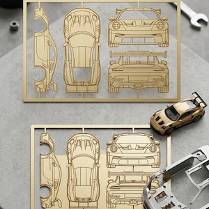 Peut inclure: Un kit de modèle de voiture doré avec plusieurs pièces, dont le châssis, la carrosserie et les roues. Le kit comprend le texte "GT3RS" et un modèle de voiture doré terminé. Une clé et d'autres outils sont en arrière-plan.