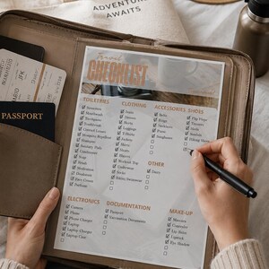Puede incluir: Un organizador de viaje de cuero marrón contiene una lista de verificación de viaje con categorías como artículos de tocador, ropa y electrónica. El texto "Travel Checklist" es visible. Un pasaporte y billetes de avión están en el organizador. Una bolsa de mano con "Adventure Awaits".
