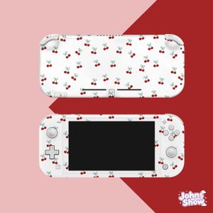 Peut inclure: Une protection pour console de jeu portable blanche avec un motif répétitif de petites cerises rouges aux tiges vertes. La protection recouvre l'avant et l'arrière de l'appareil, y compris la zone autour de l'écran, des boutons et des joysticks.