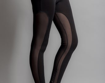 May include: Black leggings with sheer mesh panels on the sides. The leggings are fitted and have a high waist.