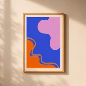 Peut inclure: Une impression d'art mural rectangulaire dans un cadre en bois clair présentant une composition abstraite audacieuse. Le design se compose d'un fond bleu vif avec une grande forme rose aux bords doux en haut à droite et une zone orange unie en bas à gauche.