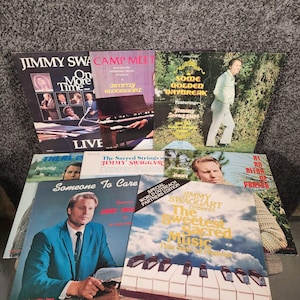 May include: A collection of eight vinyl record albums featuring Jimmy Swaggart. The covers display various photographs of the artist, musical instruments like pianos and organs, and text titles including One More Time, Camp Meeting, and The Sweetest Sacred Music.