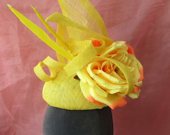 Yellow pillbox hat with flower and feathers
