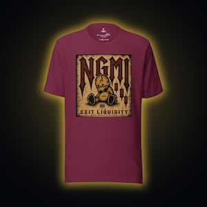 May include: Burgundy t-shirt featuring a distressed graphic with the text "NGMI" in a gothic font. The graphic includes a sad teddy bear and the words "EXIT LIQUIDITY". The shirt has a crew neck and short sleeves.