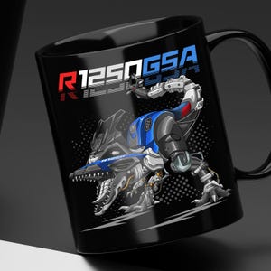 May include: Black ceramic mug featuring a stylized illustration of a motorcycle transformed into a robotic dinosaur. The design incorporates blue, red, white, and gray elements, with the text "R1250GSA" prominently displayed in red and blue.