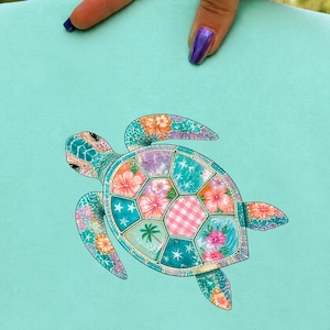 May include: A light mint green fabric square featuring a central graphic of a sea turtle. The turtle shell is composed of various patterned segments including pink hibiscus flowers, teal stars, a small palm tree, and a pink and white gingham check.