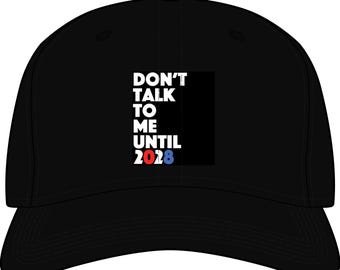 May include: A black baseball cap featuring white text on the front that reads DON'T TALK TO ME UNTIL 2028. The number 2028 is printed in a combination of red, white, and blue colors. The cap has a curved brim and a structured crown design.