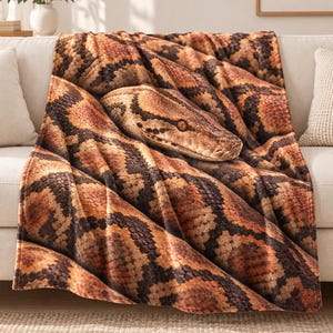 May include: A rectangular throw blanket featuring a high-resolution photographic print of a snake with orange, brown, and black scales. The design displays the detailed texture of the reptile's skin and includes a clear view of the snake's head.
