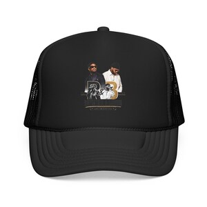 May include: A black trucker hat featuring a graphic print on the front panel. The design includes two men, the text R&B, and the words PARTYNEXTDOOR and JEREMIH. The hat has a solid front panel and a mesh back with an adjustable snapback closure.