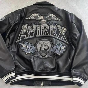 Peut inclure: Veste en cuir noir avec le logo Avirex et un grand embl&egrave;me d'aigle au dos. La veste pr&eacute;sente un ourlet c&ocirc;tel&eacute; avec des rayures blanches et une fermeture &eacute;clair. Le design comprend le texte "75 Aviator's King".