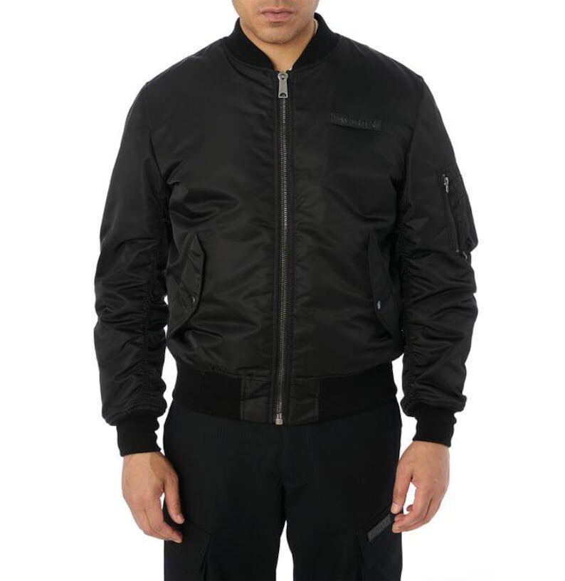 May include: Black bomber jacket with a ribbed collar, cuffs, and hem. The jacket features a front zipper closure, two side pockets, and a small pocket on the left sleeve. A small patch is visible on the chest.