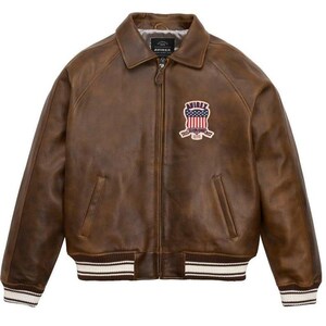 May include: Brown leather jacket with a zip-up front, collar, and ribbed cuffs and hem. Features a patch with an American flag design and the brand name "AVIREX". A classic bomber jacket style.