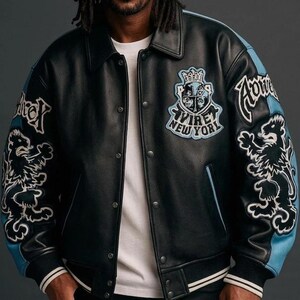 Puede incluir: Chaqueta de cuero negra con detalles en azul claro en las mangas. Cuenta con parches bordados con un le&oacute;n y el texto "AVIRE NEW YORK". La chaqueta tiene cierre de botones y cuello cl&aacute;sico.