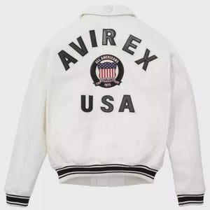 Puede incluir: Chaqueta bomber blanca con ribete a rayas blancas y negras. La parte trasera presenta el texto "AVIREX" sobre un emblema circular y la palabra "USA". El emblema incluye el texto "ALL AMERICANS ESTABLISHED 1975".