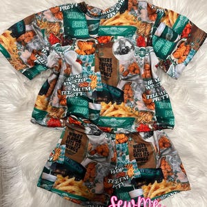 May include: A short-sleeved shirt and shorts set featuring an all-over print of Wingstop food items, including fried chicken, french fries, and drink cups. The design includes text such as "Where flavor gets its wings" and "Buy me Wingstop".