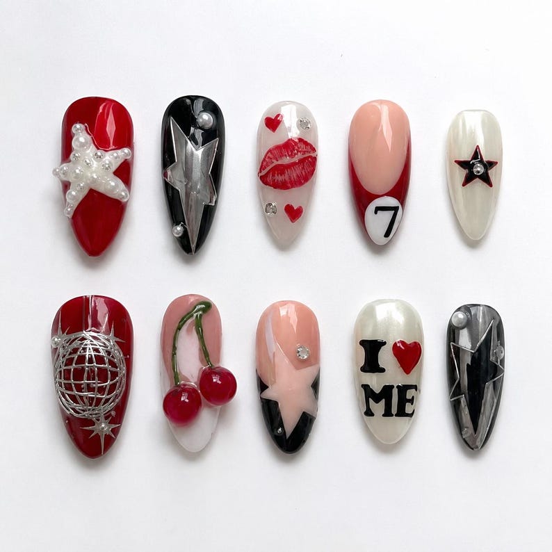 May include: A set of ten artificial nails with various designs. The nails feature red, black, and white bases, adorned with stars, lips, cherries, and the text "I ❤️ ME". Some nails have 3D embellishments.