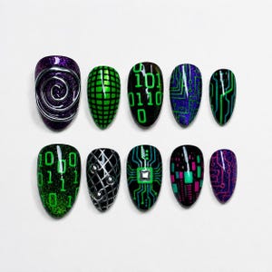 Könnte beinhalten: Ein Set aus zehn künstlichen Nägeln mit verschiedenen Designs. Die Nägel weisen Farben wie Lila, Grün, Schwarz und Silber auf. Designs umfassen Binärcode, Leiterplattenmuster und geometrische Formen. Einige Nägel haben Glitzerakzente.