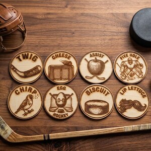 May include: Eight circular wooden coasters featuring laser-engraved hockey-themed illustrations and text including Twig, Cheese, Assist, Five Hole, Chirp, Egg Hockey, Biscuit, and Lip Lettuce, surrounded by a vintage helmet, puck, and hockey stick.