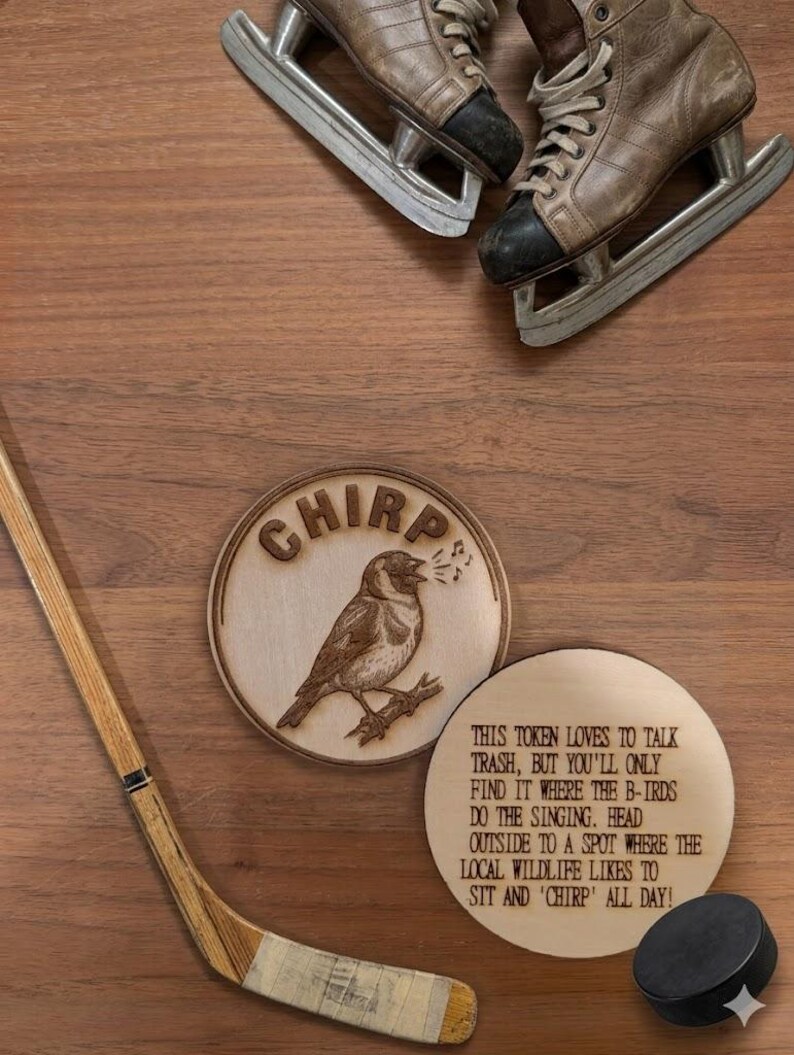 May include: Two circular wooden tokens with laser-engraved designs. One token features a bird on a branch with the text CHIRP. The other token displays the text: THIS TOKEN LOVES TO TALK TRASH, BUT YOU'LL ONLY FIND IT WHERE THE B-IRDS DO THE SINGING.