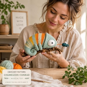 May include: A crocheted chameleon toy in light blue, yellow, and orange, perched on a brown branch. The chameleon has a long orange tongue extending to a small blue fly. A rectangular label reads: CROCHET PATTERN CHAMELEON CONRAD MUSICAL TOY.
