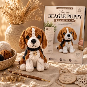 Può includere: Un cucciolo di beagle amigurumi all'uncinetto in filato marrone, bianco e nero, con un collare nero e un ciondolo a forma di zampa dorata. Accanto c'è un libretto di istruzioni intitolato Classic BEAGLE PUPPY AMIGURUMI.