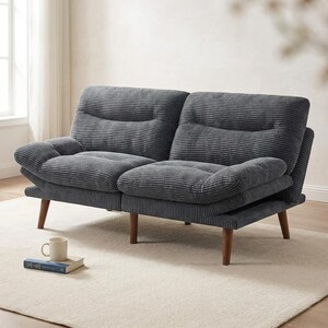 May include: A grey corduroy two-seater sofa with wooden legs. The sofa has a ribbed texture and a low profile. A white mug and a book rest on the floor in front of the sofa.