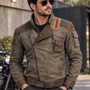 Könnte beinhalten: Eine olivgrüne Jacke mit diagonalem Reißverschluss, hohem Kragen und dunkelbraunen, strukturierten Schulterpartien. Die Jacke verfügt über mehrere Utility-Taschen an Brust und Ärmeln, einen breiten Taillengürtel und einen roten rechteckigen Aufnäher.