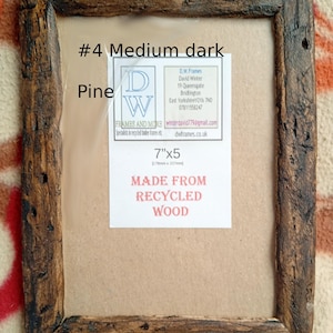 May include: A rectangular picture frame crafted from dark, weathered recycled pine wood. The frame features a rustic, textured surface and contains a white insert with the text #4 Medium dark Pine, 7"x5, and MADE FROM RECYCLED WOOD.