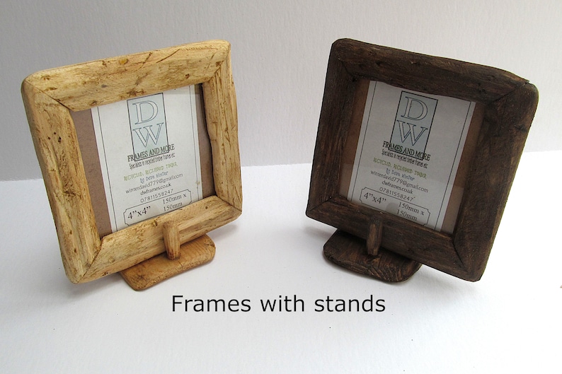 May include: Two square wooden picture frames with stands, one light-toned and one dark-toned. Each frame features a textured, rustic border and contains a white insert with the text DW FRAMES AND MORE, 4"x4", and 150mm x 150mm. The frames are supported by small, matching wooden bases.