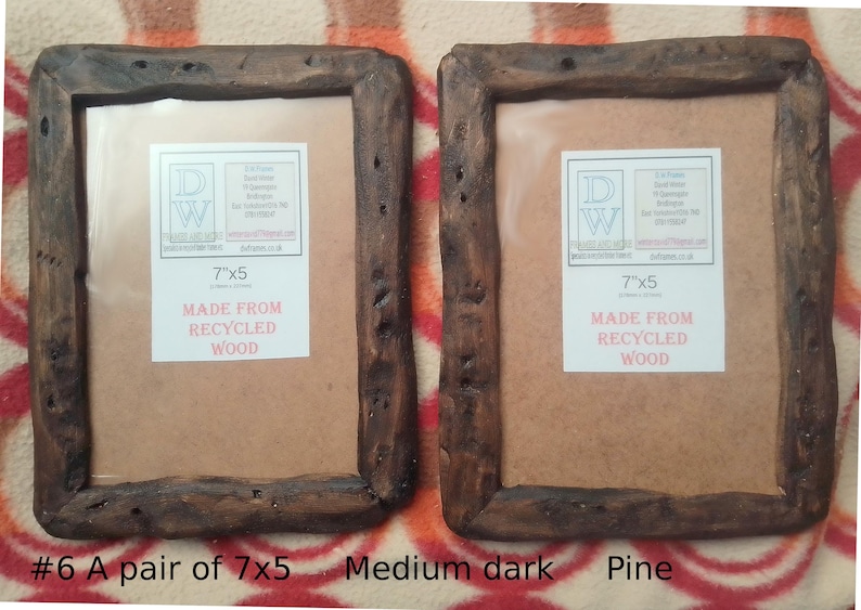 May include: A pair of rectangular picture frames crafted from dark brown recycled wood with a rough, natural texture. Each frame features a white insert label with the text 7"x5" and MADE FROM RECYCLED WOOD. The frames have a rustic appearance.
