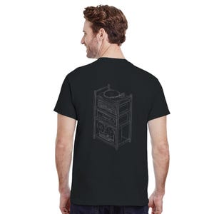 Könnte beinhalten: Ein schwarzes Kurzarm-T-Shirt mit einer weißen Linienzeichnung auf der Rückseite. Die Illustration zeigt ein mehrstöckiges Hi-Fi-Rack mit einem Plattenspieler, einem Verstärker und einem Tonbandgerät in einem schlichten Umriss-Stil.