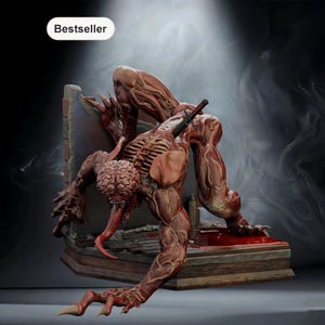 May include: A detailed sculpture of a grotesque creature with exposed muscle tissue, a large brain, and a long tongue. The figure is posed on a book, with a knife embedded in its back. The word "Bestseller" is displayed.