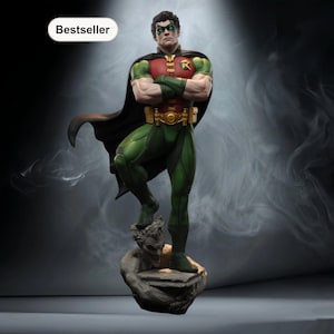 Puede incluir: Estatua detallada de Robin, un superhéroe de DC Comics, en una pose dinámica. La figura viste un traje verde y rojo con una capa negra y un cinturón dorado. La estatua está montada sobre una base de piedra y tiene una etiqueta de "Bestseller".