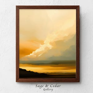 Könnte beinhalten: Ein gerahmter Kunstdruck mit einem Landschaftsgemälde eines Sonnenuntergangs mit goldgelben und orangefarbenen Wolken über einem dunklen Horizont. Das Kunstwerk ist in einem dunkelbraunen Holzrahmen gefasst. Der Text Sage & Cedar Gallery ist sichtbar.