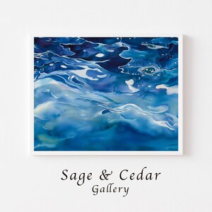 Könnte beinhalten: Ein rechteckiger Wandkunstdruck mit einer abstrakten Darstellung von tiefblauem und türkisfarbenem Wasser mit weißen Lichtreflexionen auf der Oberfläche. Der Text Sage & Cedar Gallery ist in schwarzer Serifenschrift unter dem gerahmten Bild gedruckt.