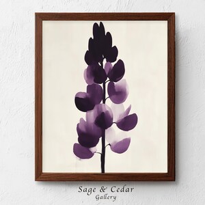 Könnte beinhalten: Ein gerahmter Kunstdruck mit einer vertikalen Illustration einer Lupinenblüte in tiefen Violett- und Lavendeltönen vor einem cremeweißen Hintergrund. Das Kunstwerk befindet sich in einem dunkelbraunen Holzrahmen mit schlichtem Profil.