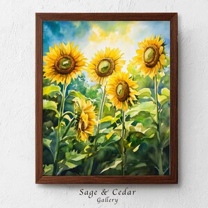 Könnte beinhalten: Ein gerahmtes Aquarellbild von vier leuchtend gelben Sonnenblumen mit dunklen Mitten vor einem Hintergrund aus grünem Blattwerk und einem sanften blau-gelben Himmel. Das Kunstwerk befindet sich in einem dunkelbraunen Holzrahmen.