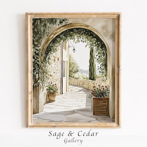 Peut inclure: Une impression d'art encadrée représentant une arche en pierre menant à un chemin ensoleillé. La scène présente des vignes vertes grimpantes, des fleurs rouges en pot, un cyprès et une lanterne. Le texte Sage & Cedar Gallery est inscrit.