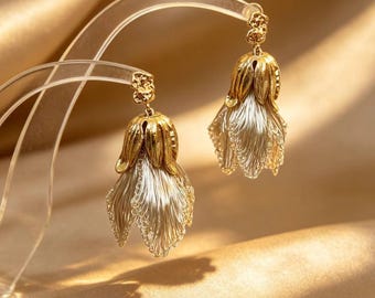 Orecchini pendenti a forma di mughetto realizzati a mano all'uncinetto con filo metallico, bicolore oro e argento, con fiori pendenti, ideali come regalo per matrimoni e damigelle d'onore.