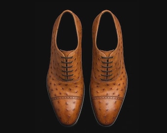 Zapatos Oxford de piel de avestruz color camel, diseño con puntera reforzada y cierre de cordones.