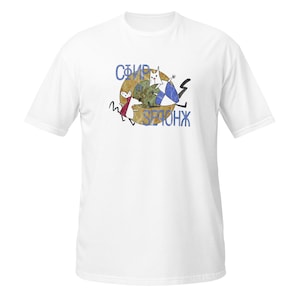 May include: A white short-sleeved t-shirt featuring a central graphic of a stylised cat and mouse in front of a textured brown circle. The design includes blue text that reads "СФИР" and "SЕРОНЖ" positioned around the illustrated animal figures.