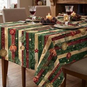 Könnte beinhalten: Eine rechteckige Tischdecke mit einem festlichen Muster aus vertikalen Streifen in Dunkelgrün, Dunkelrot und Creme. Das Design ist mit Illustrationen von hängenden Weihnachtskugeln, Tannenzweigen und kleinen roten Sternen verziert.