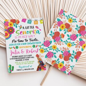 May include: Baby shower invitation with the text "A Little Senorita Is On Her Way!" in turquoise and pink. The invitation features colorful floral and decorative elements, including a cactus and maracas. The invitation is for Julia & Robert.