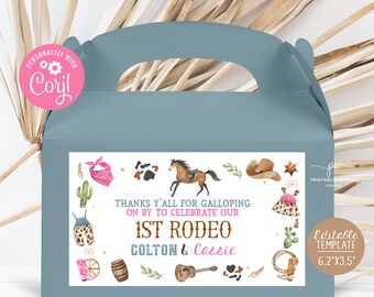 May include: A blue favor box with a white label that says "Thanks y'all for galloping on by to celebrate our 1st Rodeo Colton & Cassie". The label has a western theme with illustrations of a horse, cactus, cowboy hat, boots, and a guitar. The box is 6.2 inches by 3.5 inches.