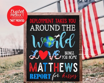 May include: A black chalkboard sign with white text that reads "Deployment takes you around the world love brings you home Matthews report for kisses". The sign has a red heart and a blue globe with a plane flying over it. The sign is framed in wood and has a red, white, and blue color scheme.